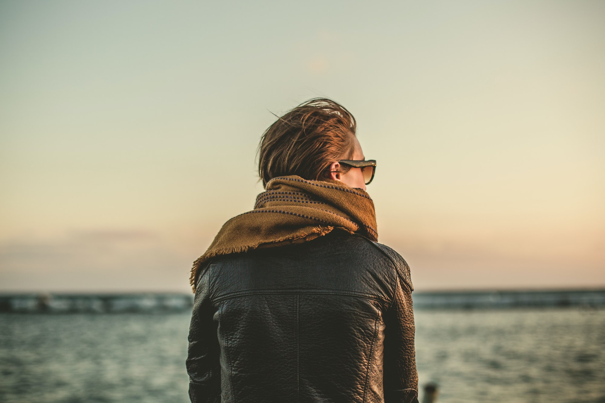 woman sits looking out at water