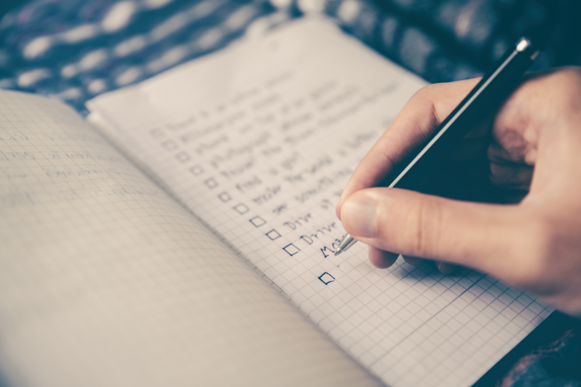 hand holding pen writing in notebook